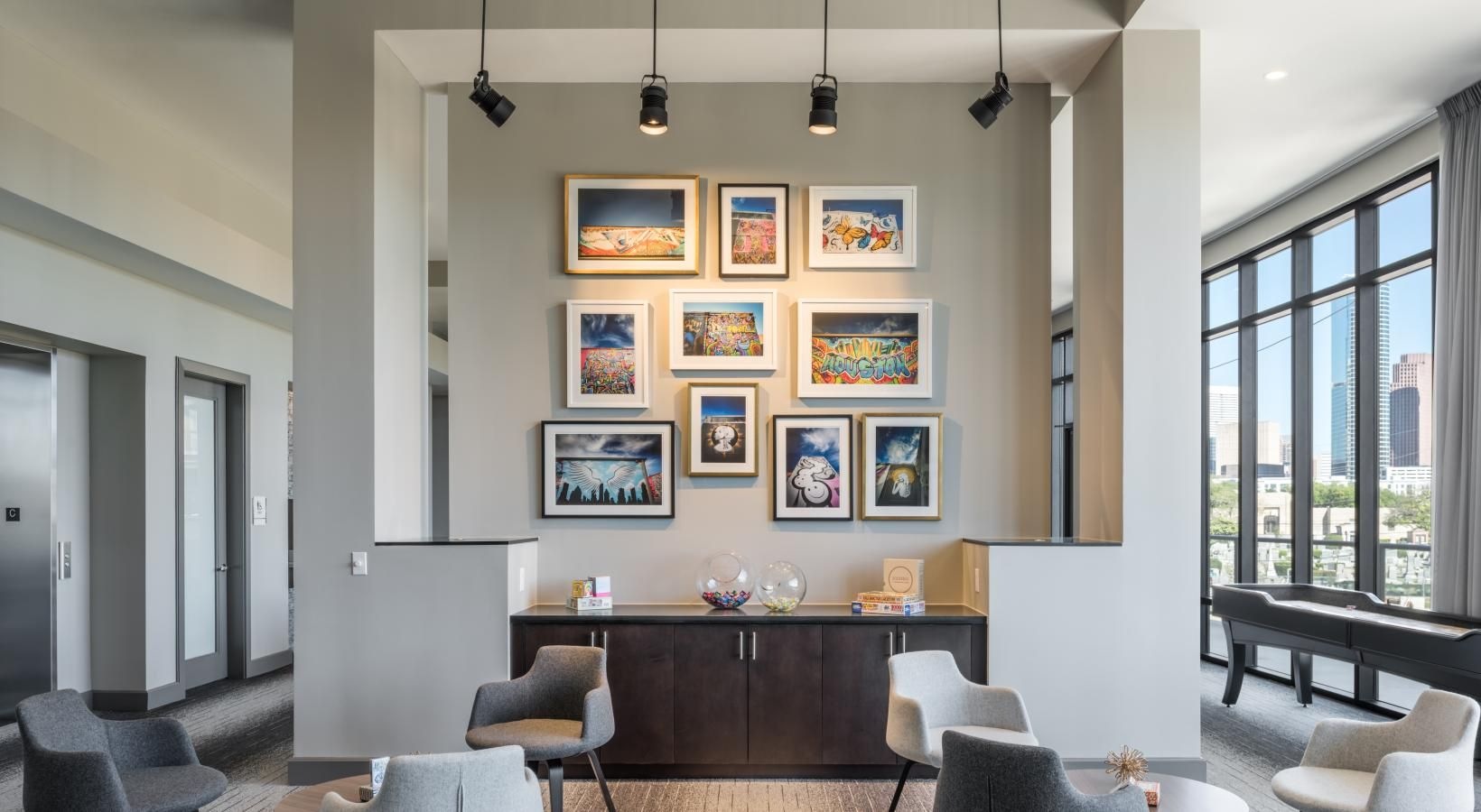 Enjoy our resident-only features a room with a table chairs and a window with art on the wall