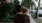 tired little girl rests her head on her father's shoulder as he carries her down the city sidewalk